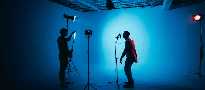 Crew shooting in a studio with blue backdrop